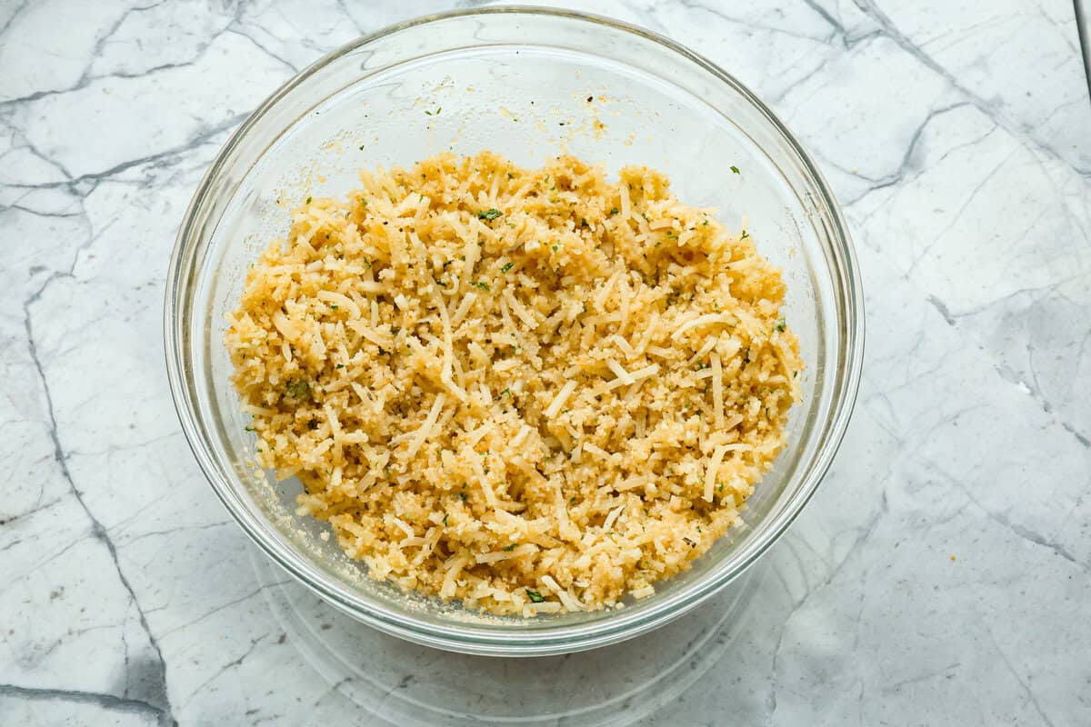This chicken tetrazzini casserole is packed with delicious flavors and textures. It has hearty chicken, tender mushrooms, peas, and pasta, all tossed in a creamy, rich sauce. The casserole is topped with crispy, buttery breadcrumbs and a sprinkle of Parmesan cheese with the most irresistible crunch and flavor. Overhead shot of topping mixture in bowl.