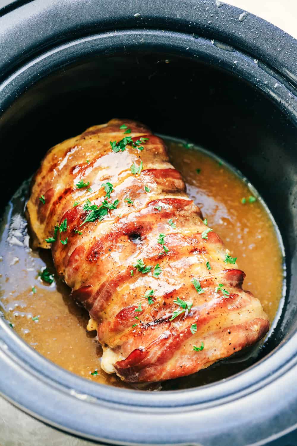 Slow Cooker Bacon-Wrapped Maple Pork after cooking in a crock pot.