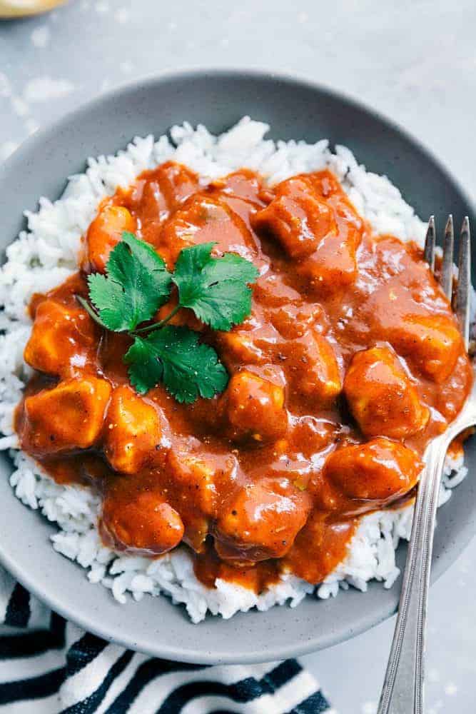 Easy Butter Chicken over white rice in a grey bowl with a fork. 