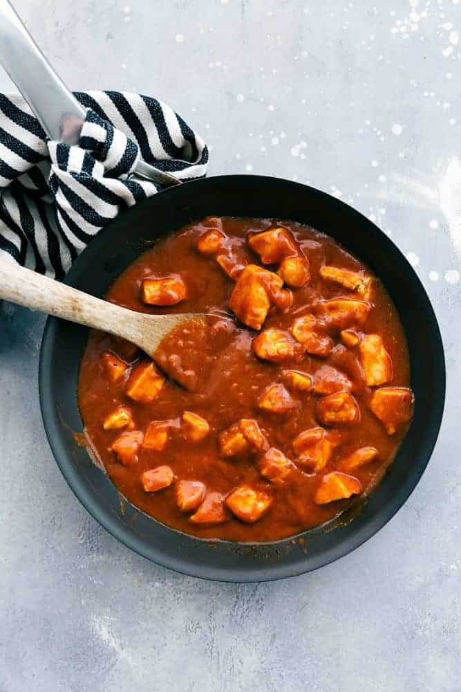 Easy Butter Chicken in a black pan with a wooden spoon. 