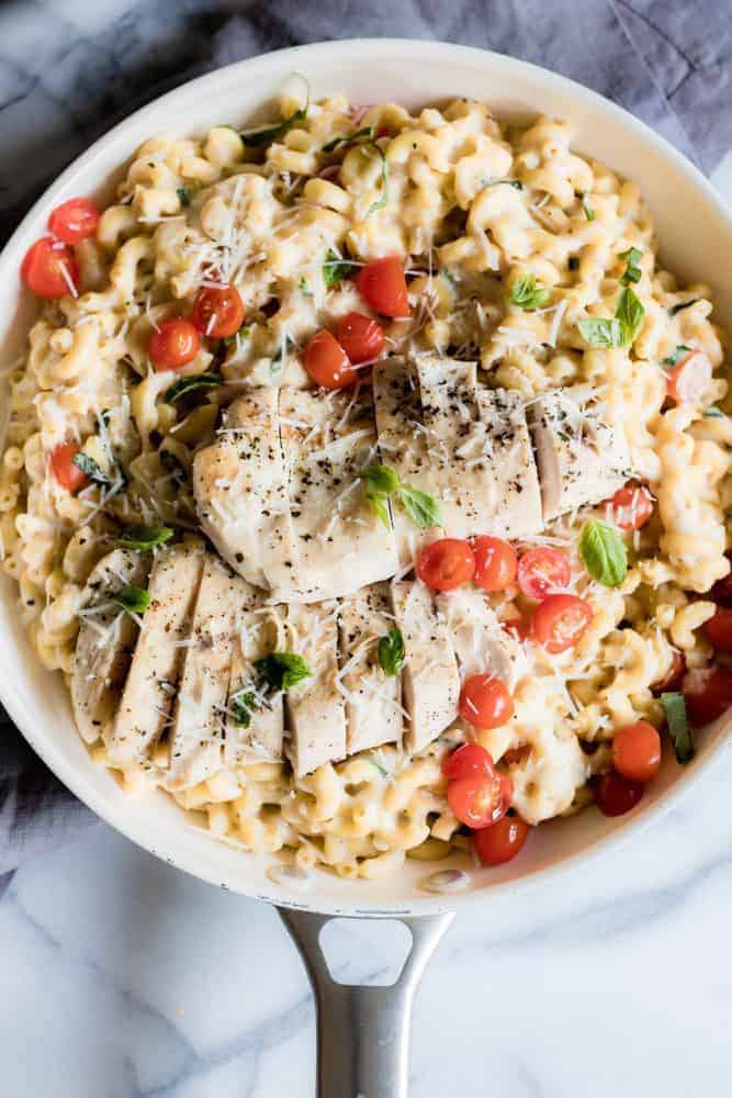 Chicken Caprese Mac and Cheese in a white skillet. 