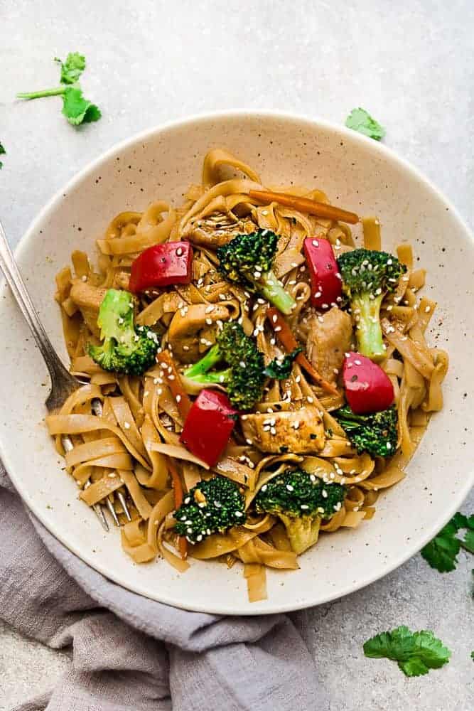 Mongolian Chicken Noodles in a white bowl with a fork. 