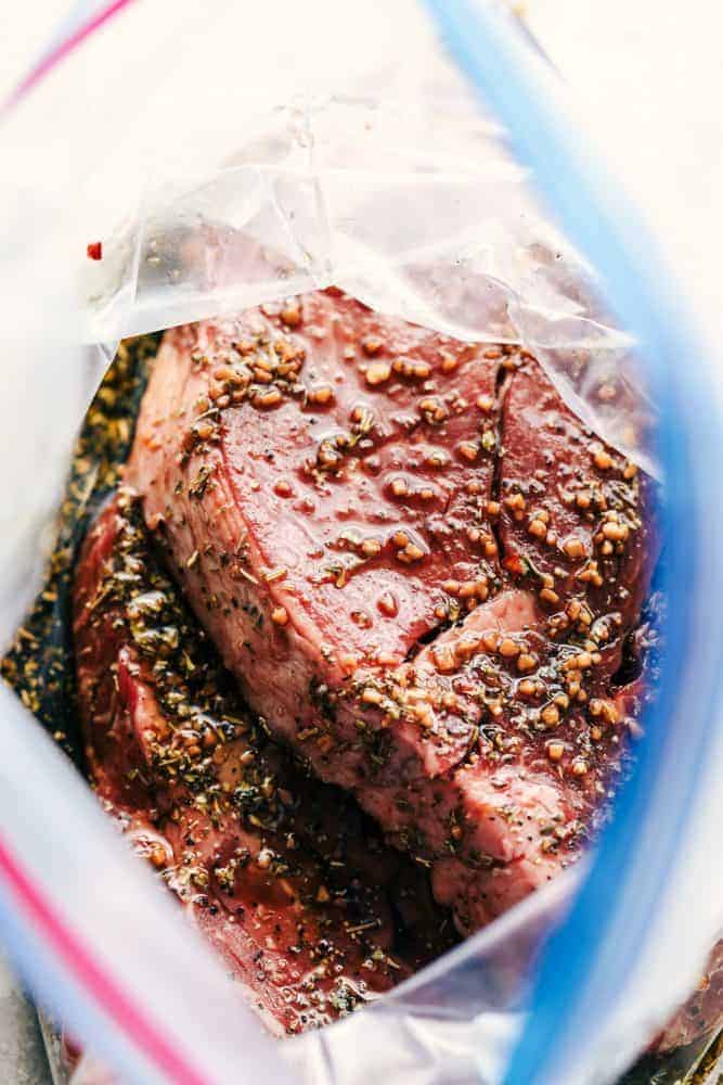 Uncooked steak in a Ziplock bag with the steak marinade. 