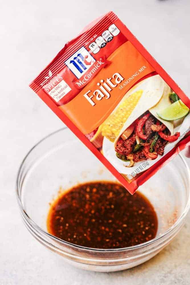 McCormick Brand Fajita seasonings being mixed in a clear bowl. 