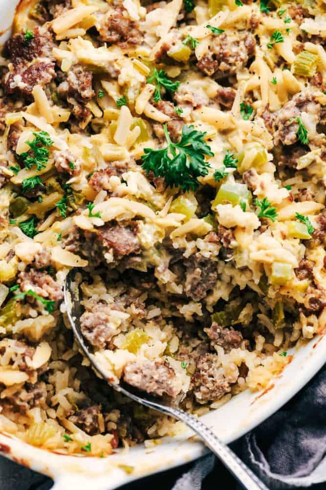 Easy Sausage and Rice Casserole in a white dish with a metal spoon. 