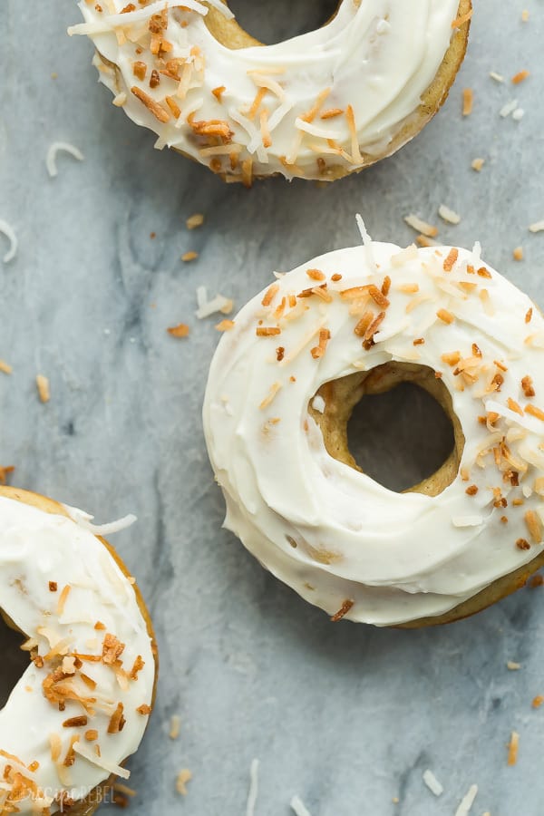 Closeup of a couple Baked Carrot Cake Donuts with Cream Cheese Frosting on a counter. 