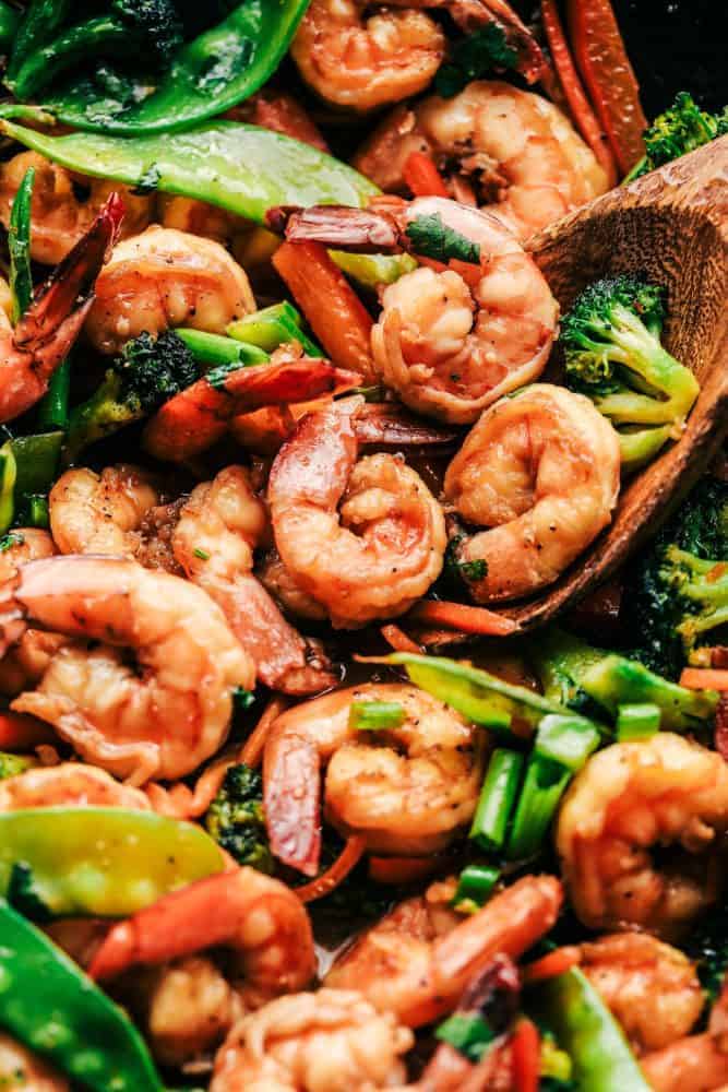 Shrimp stir fry with large shrimp, broccoli, sugar snap peas and shredded carrots. 