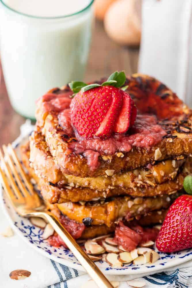 Almond French Toast with Roasted Strawberry Syrup with a fork and a glass of milk. 