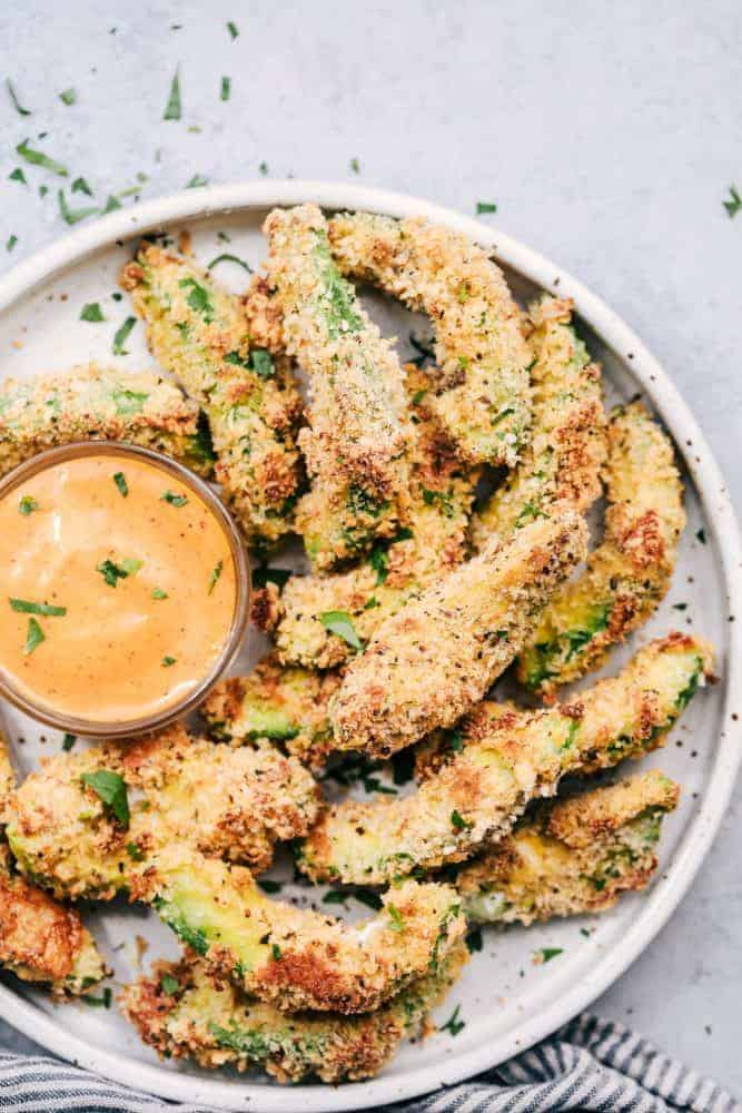 Crispy Garlic Avocado Fries with sauce on a white plate. 