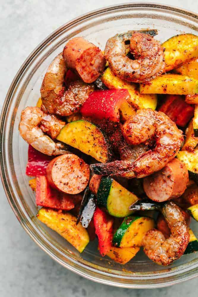 Cajun Shrimp and Sausage and Veggies in a clear bowl. 