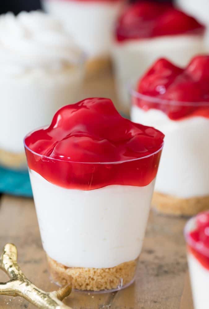 Cherry-topped cheesecake served in a shot glass.