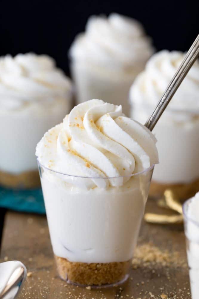 Cheesecake dessert cup topped with homemade whipped cream.