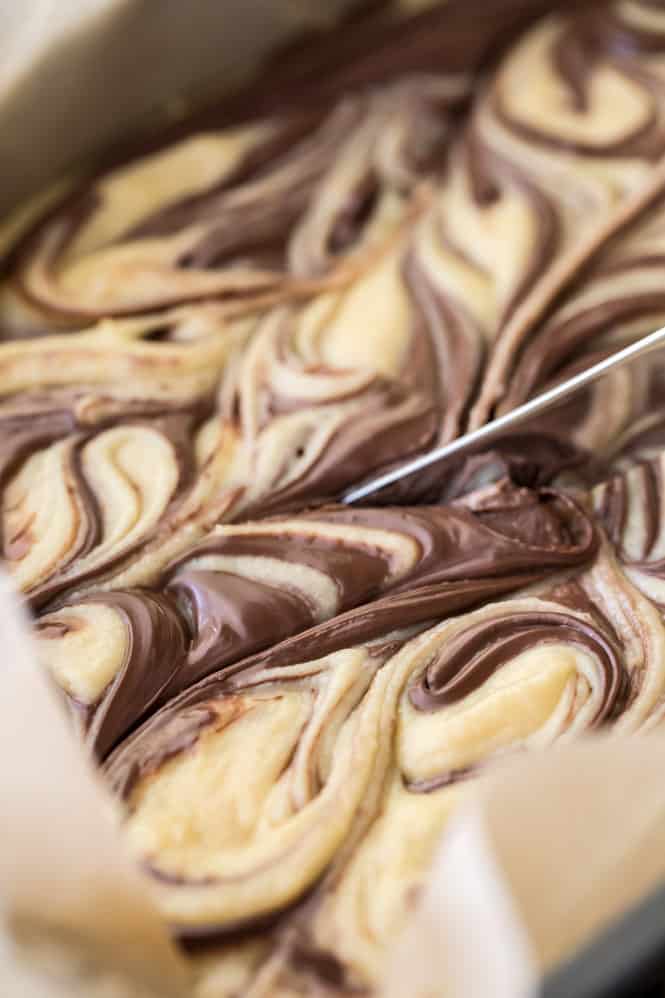Nutella blondies being sliced in a pan. 