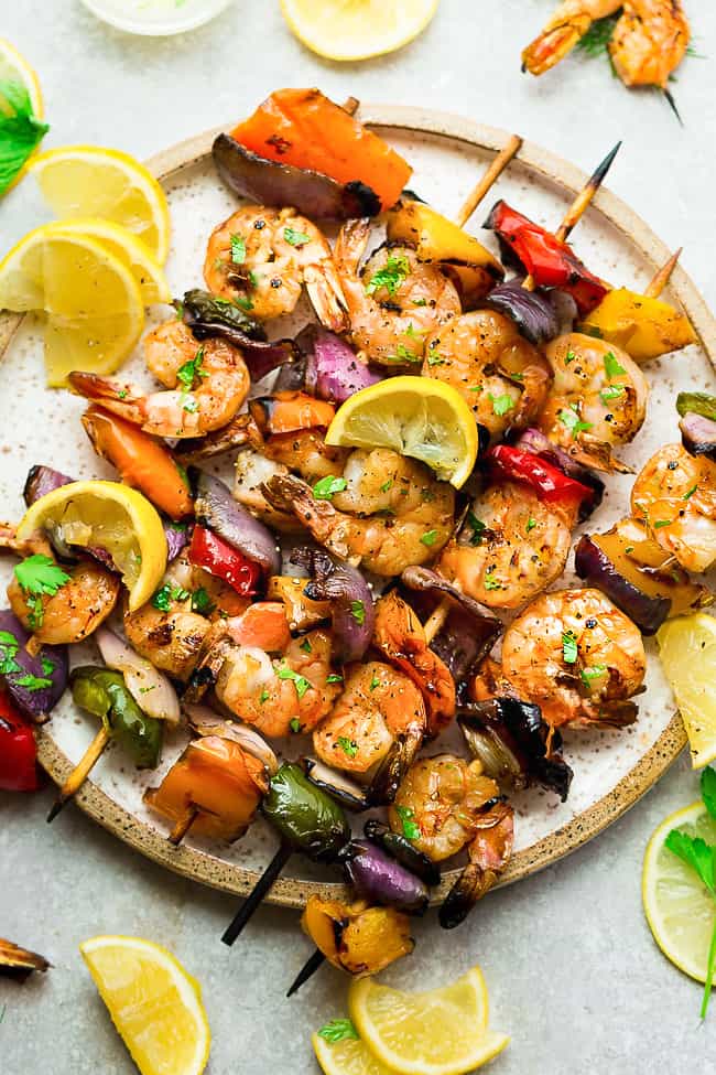 Grilled Lemon Garlic Butter Shrimp with Vegetables on a white plate.