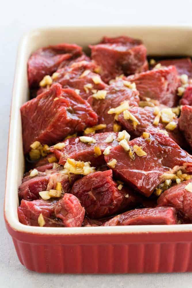 Pan of uncooked sliced up beef. 