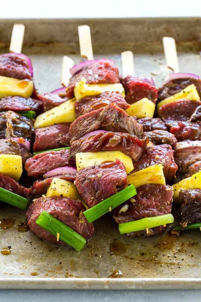 Uncooked Teriyaki Beef Skewers on a cooking sheet. 