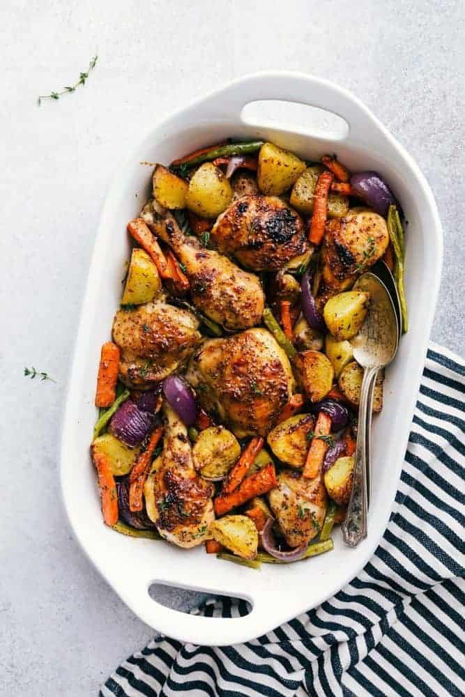 Honey mustard chicken and root vegetables in a white serving bowl. 