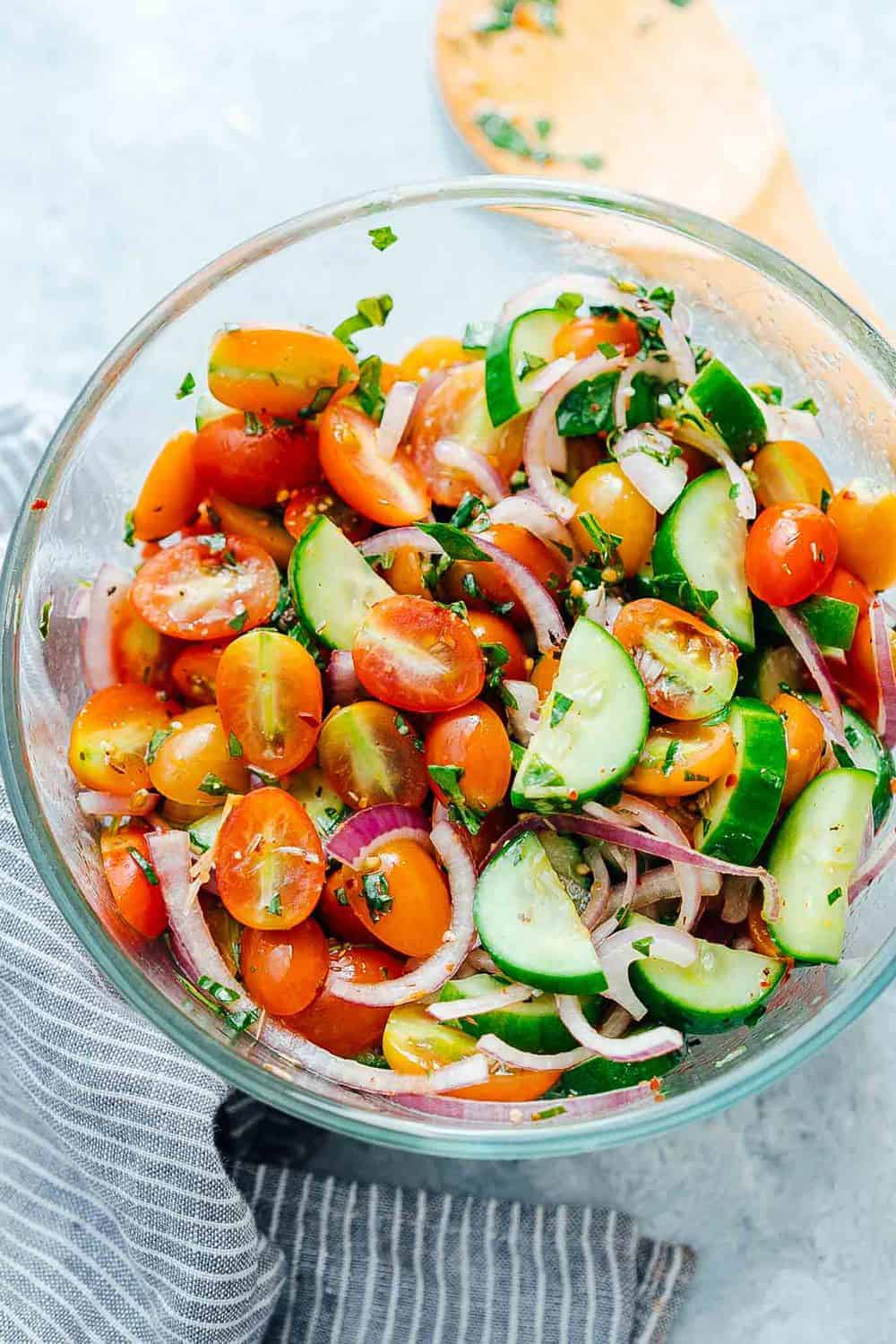 Chilled cucumber tomato salad mixed up in a bowl