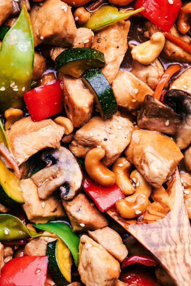 Close-up of Cashew Chicken Stir Fry with a wooden spoon. 