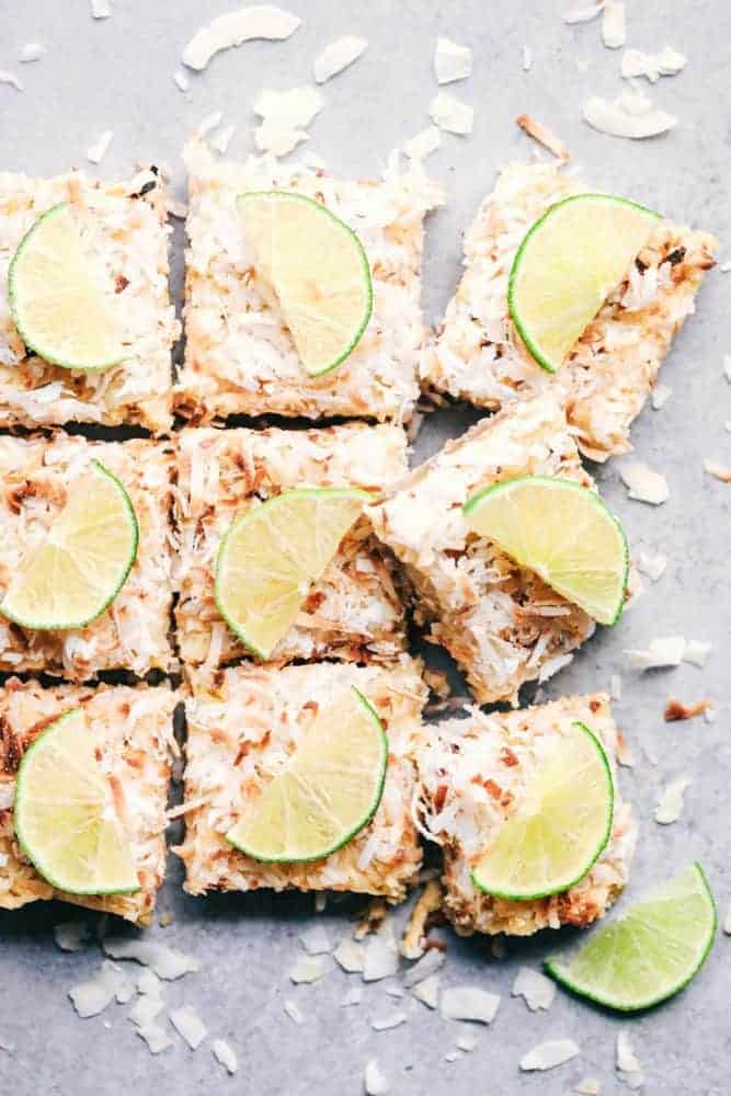 Cut Coconut Lime Butter Bars with fresh sliced limes on top. 