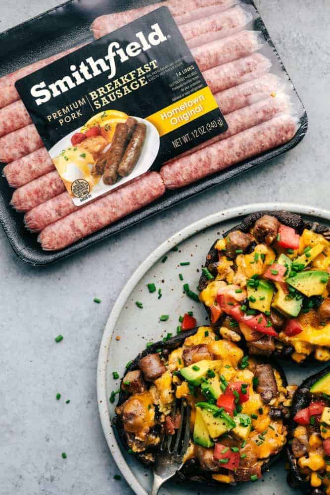 One package of Smithfield Sausage next to a white plate with Southwest Sausage and Egg Stuffed Portobello Mushrooms. 
