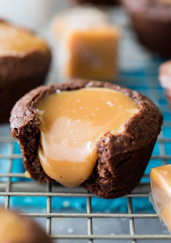 Salted Caramel Brownie Bite with caramel pouring out of the top and onto the cooling rack. 