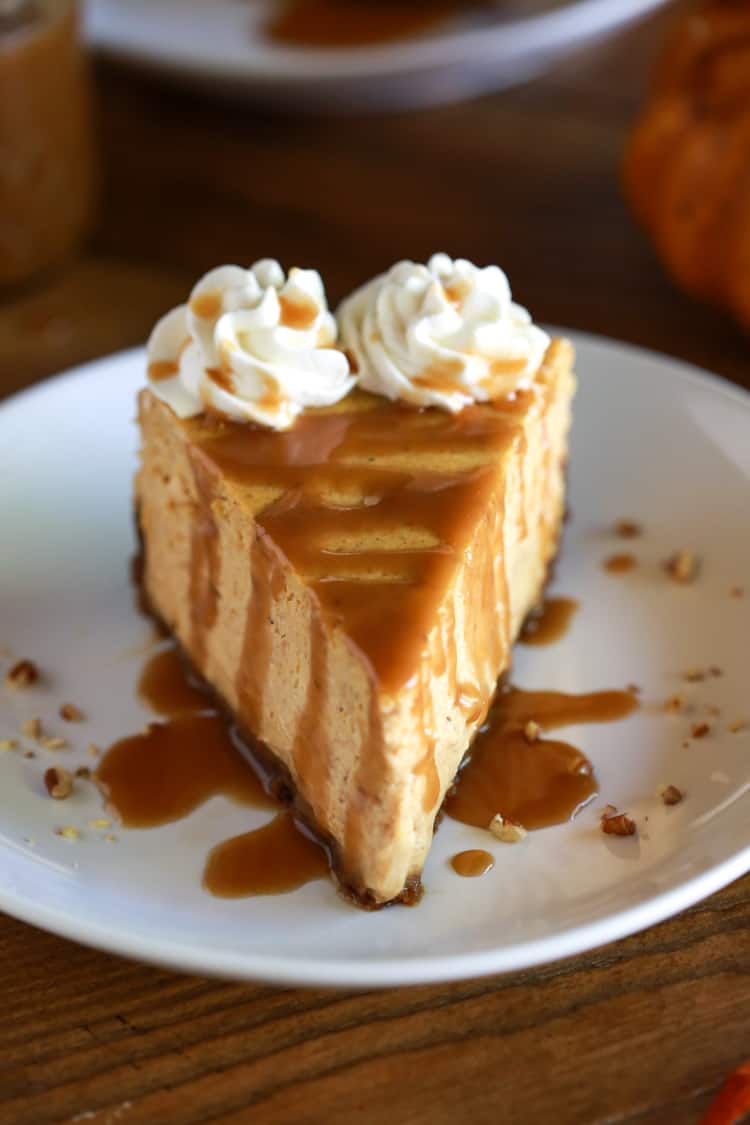 A slice of pumpkin cheesecake with caramel sauce on top.
