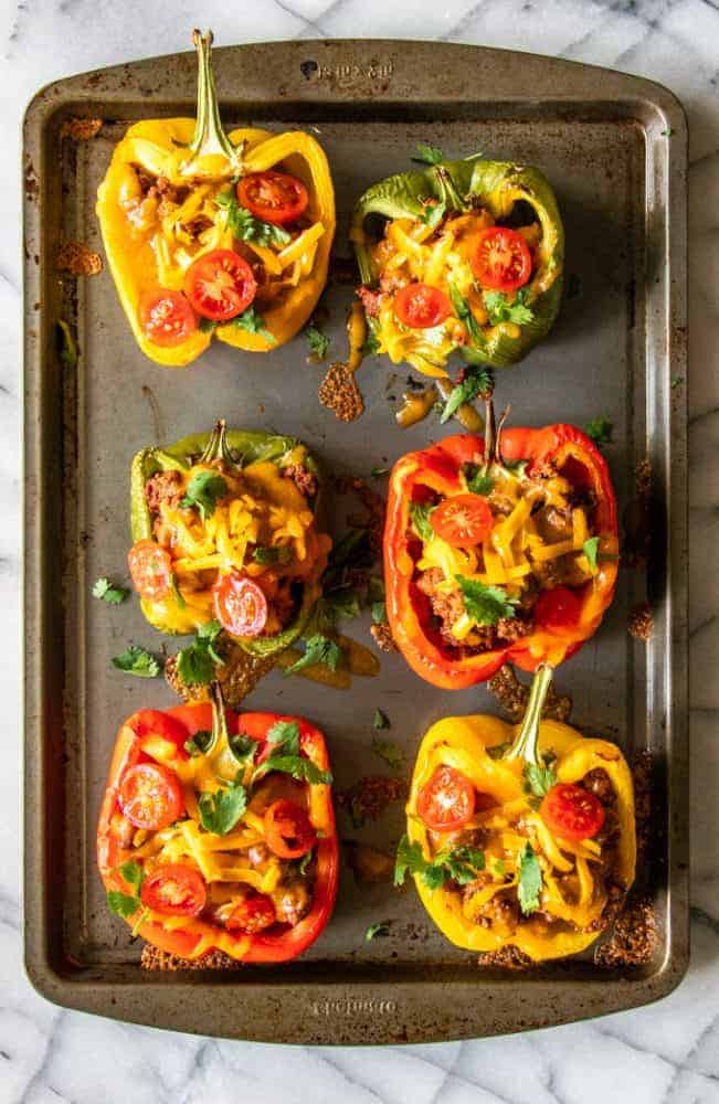 Six Taco Stuffed Peppers on a cooking sheet. 