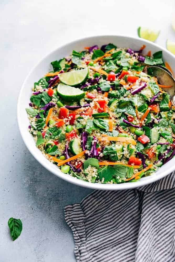 Thai quinoa salad in a white bowl with a striped cloth on the side. 