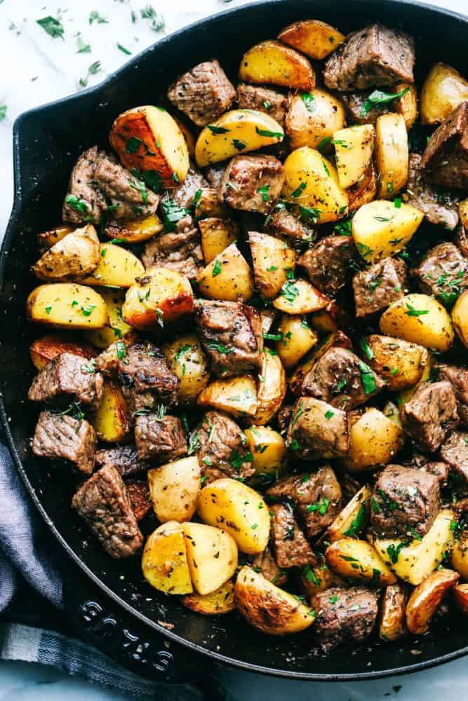 Garlic Butter Herb Steak Bites with Potatoes in a skillet. 