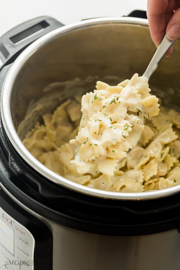 Instant pot chicken alfredo pasta with a spoon removing some. 