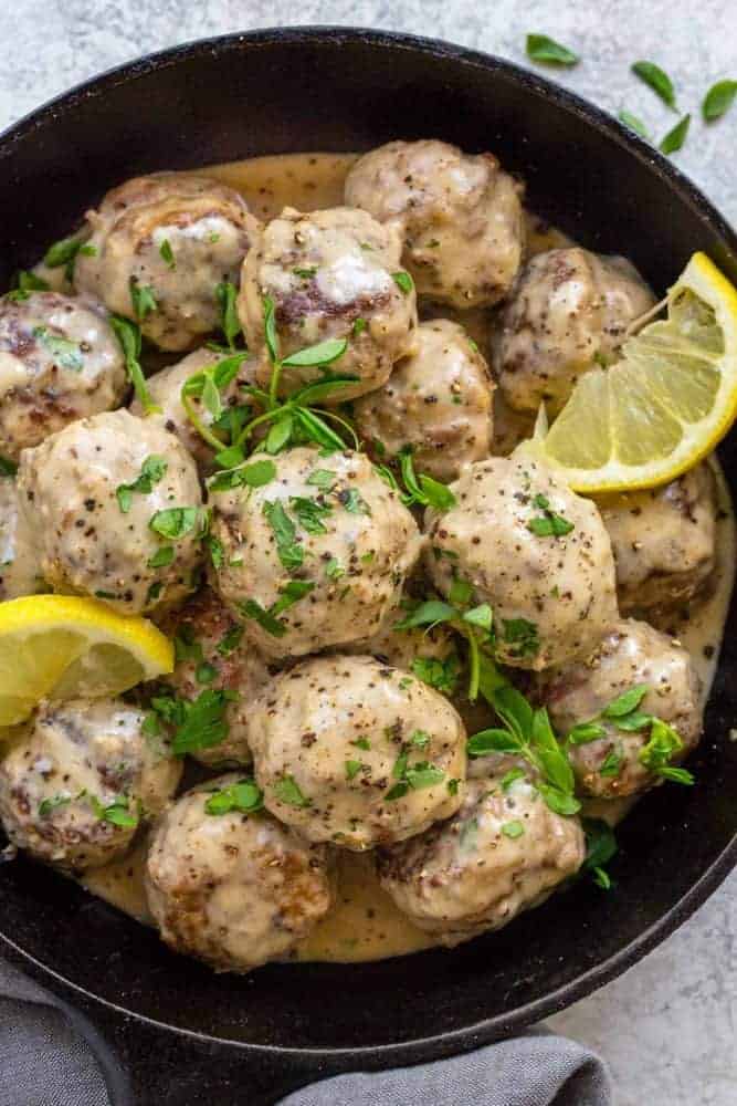 A bowl of slow cooker Swedish meatballs with garnish.