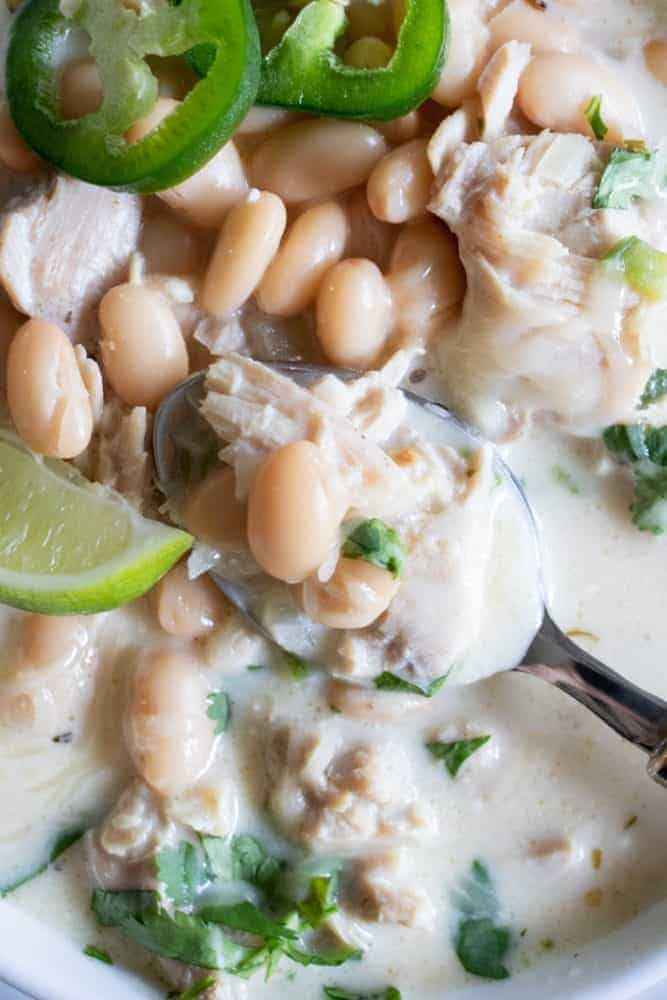 Bowl full of Creamy White Chicken Chili with a spoon. 