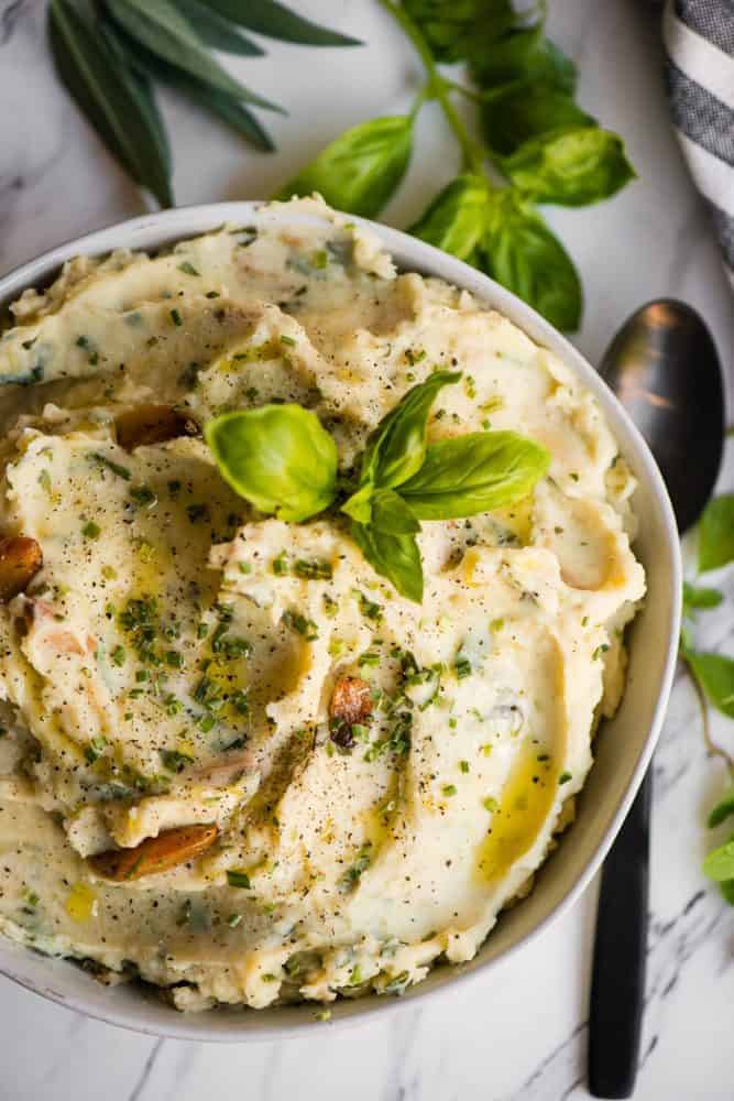 Garlic herb mashed potatoes in a white bowl.