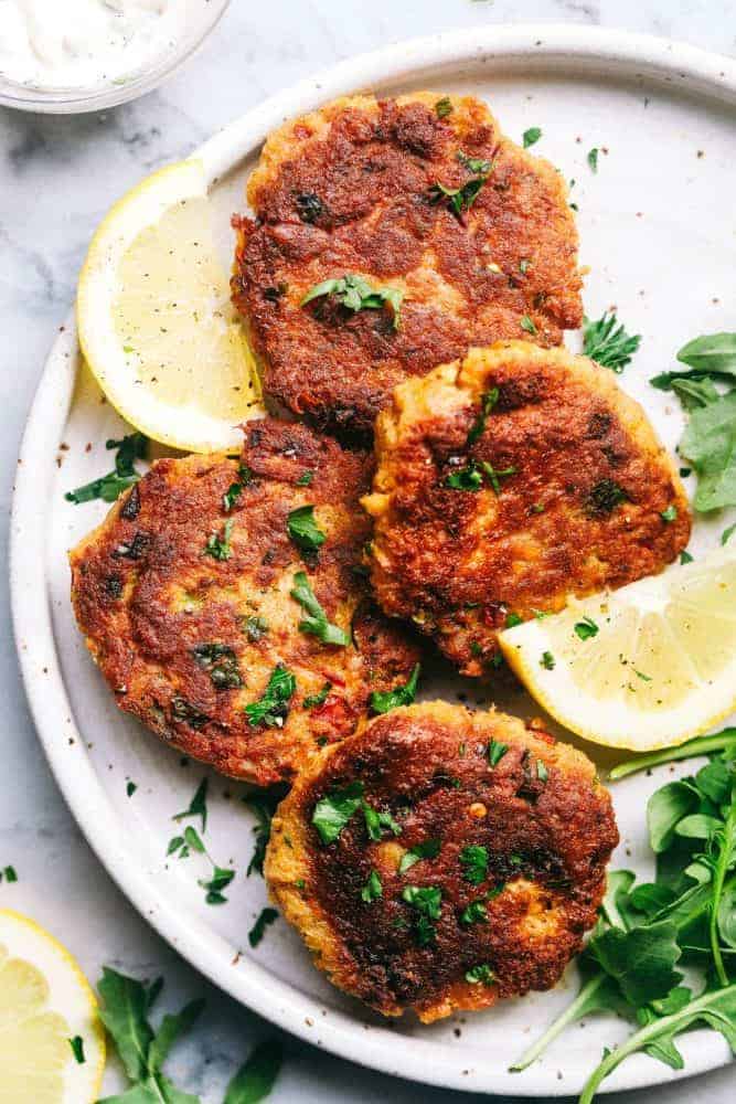 Salmon Croquettes on a white plate with freshly slices lemons. 