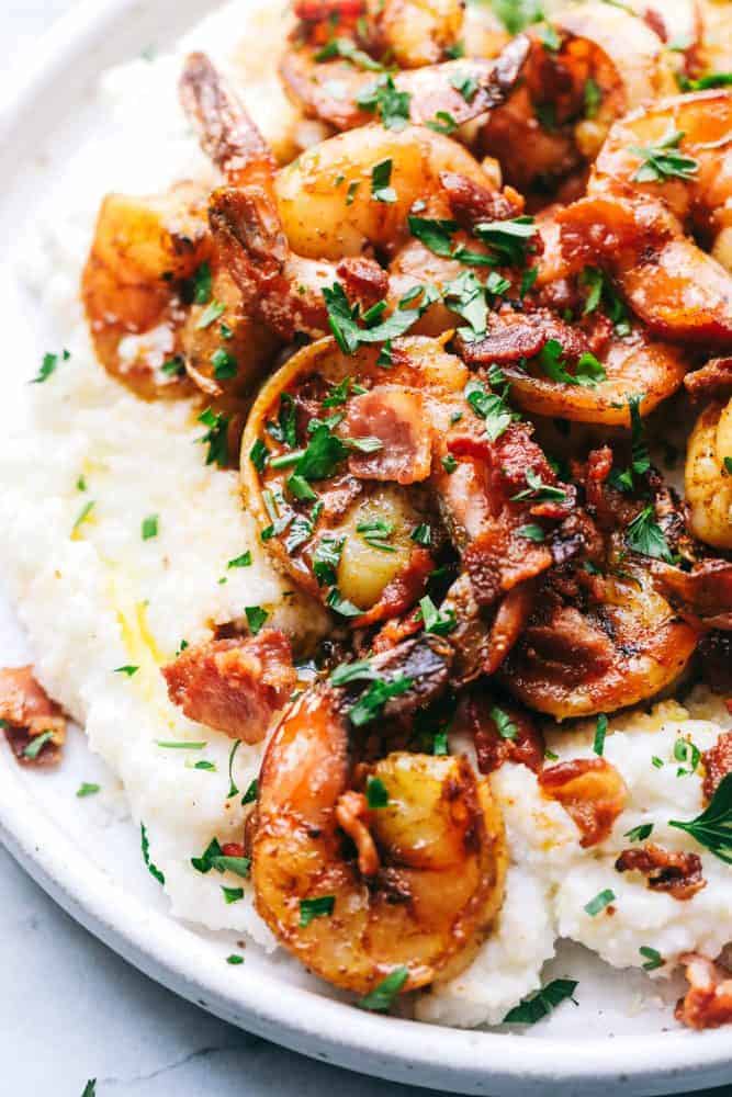 Garlic shrimp and grits on a white plate.