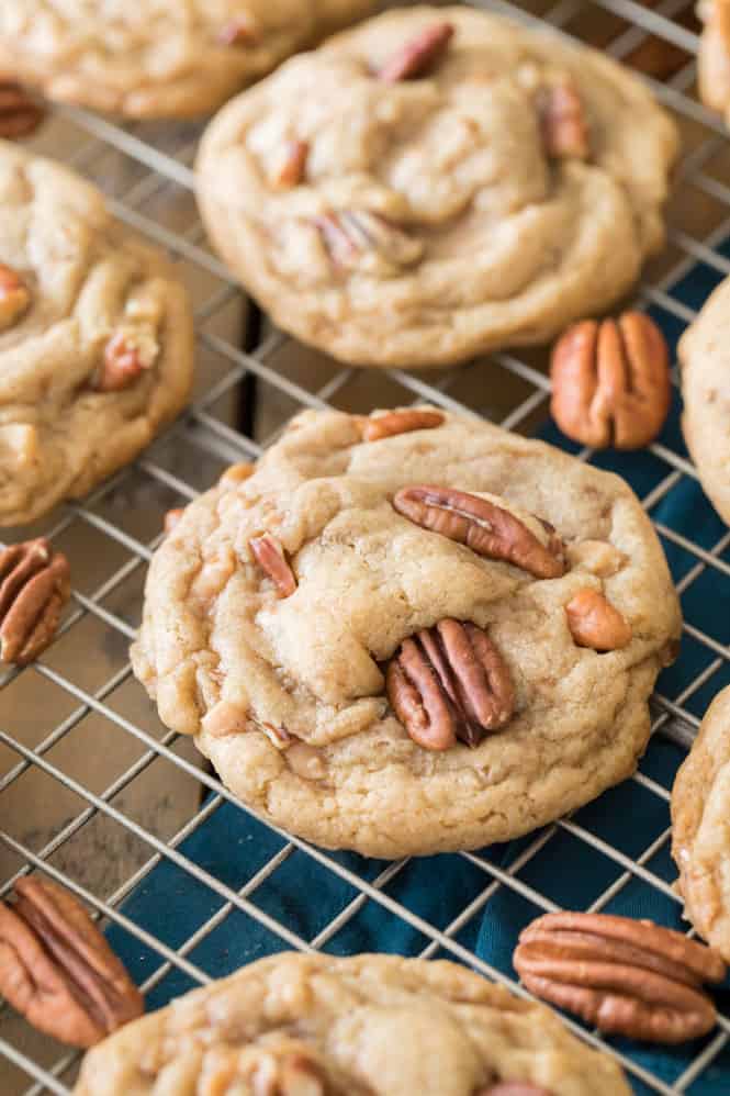 Butter pecan cookies cooling on a cooling rack garnished with more pecans on the cooling rack and cookies.