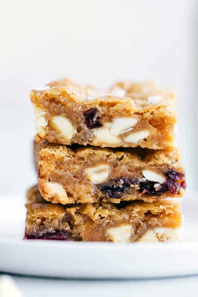 Three white chocolate cranberry Blondies stacked on top of each other.