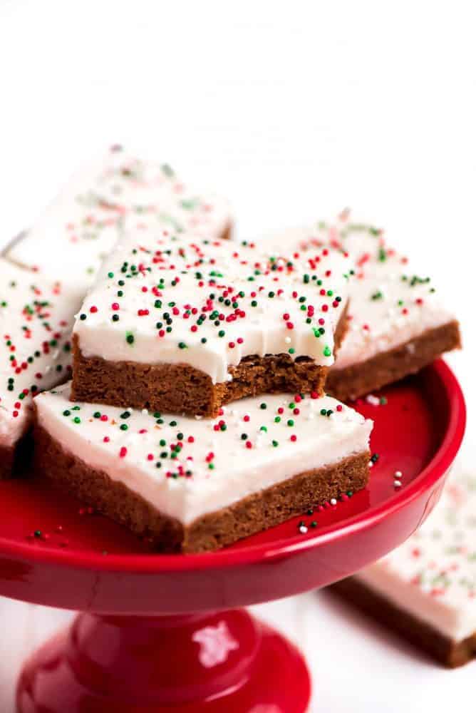 Ginger bread sugar cookie bars stacked on top of each other on a red cake stand