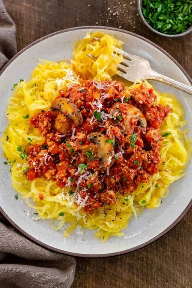 top down photo of a plate of turkey meat sauce over a bed of spaghetti squash vegetable noodles