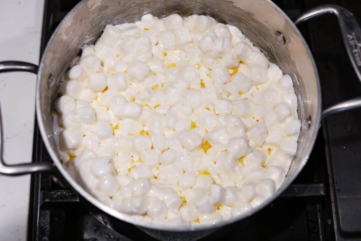 Overhead shot of mini marshmallows in the melted butter in the saucepan. 