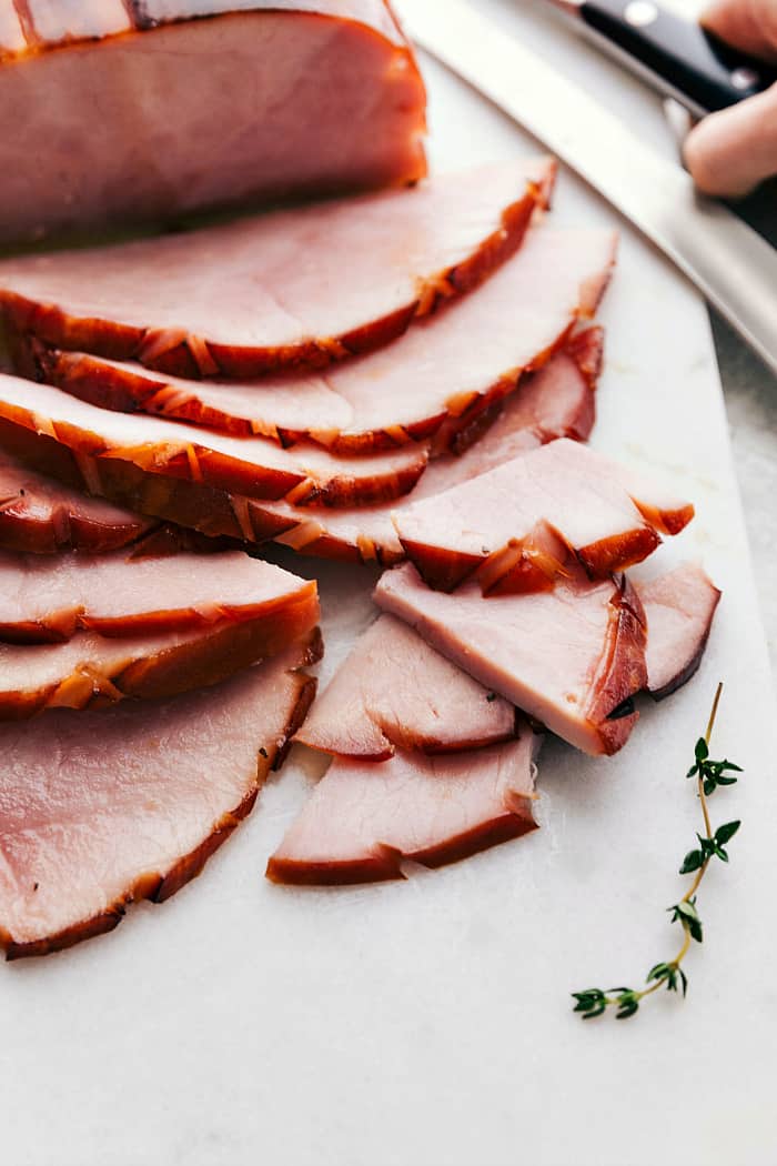 Honey glazed ham sliced on a cutting board.