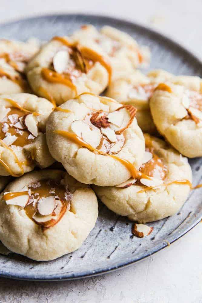 Almond thumbprint cookies on a gray plate.