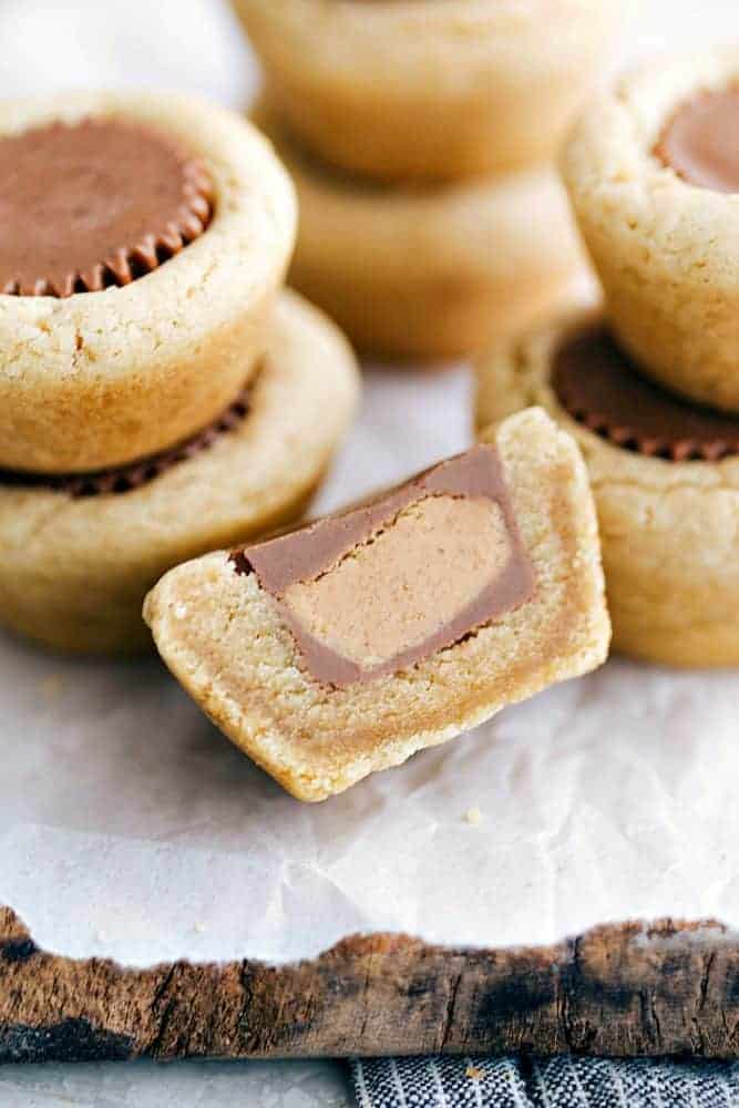 Reese's peanut butter cookies stacked on top of each other. One of themIs cut in half to show the inside
