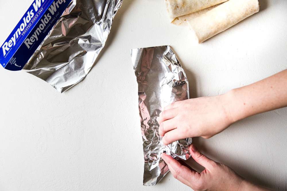 Tuck in the sides of the aluminum foil as you wrap the burrito.