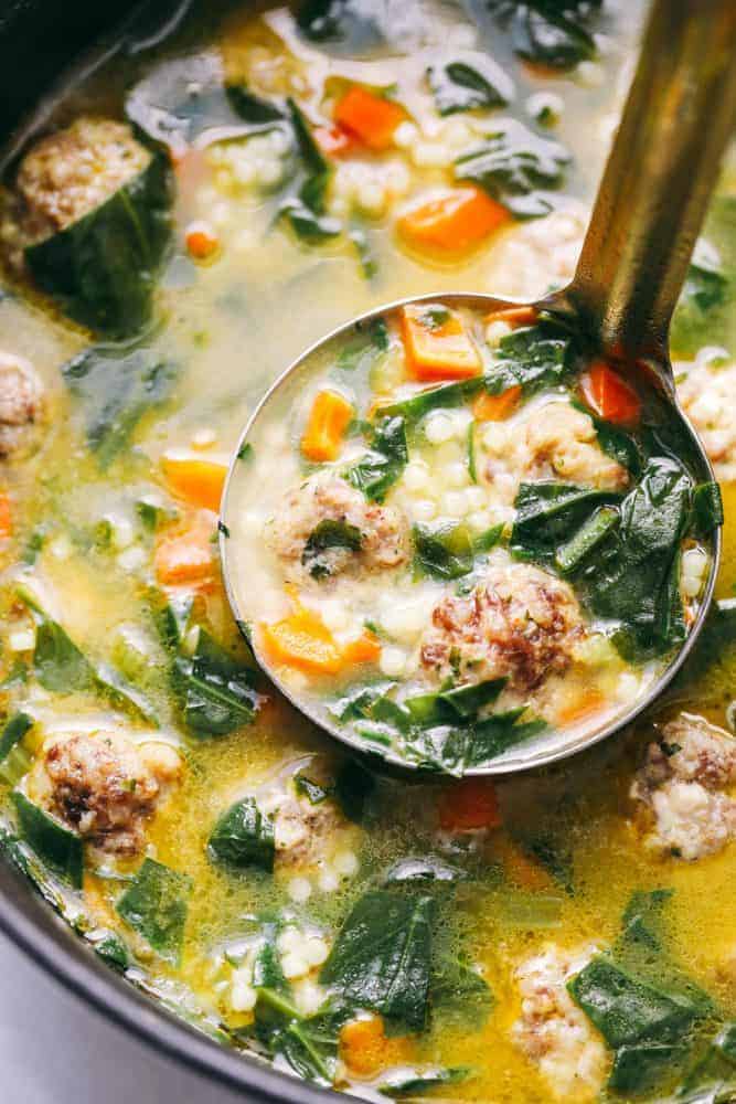 Italian wedding soup in a bowl with a ladle.