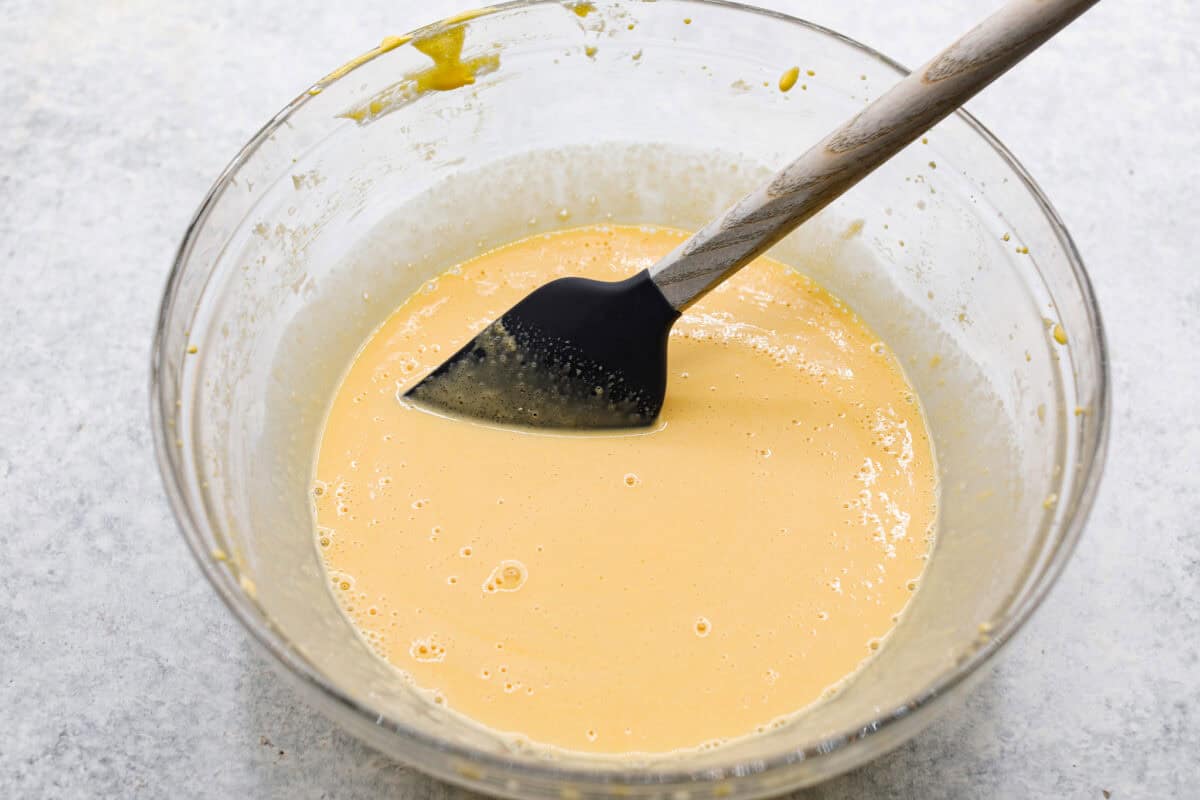 Angle shot of egg yolk and sugar mixture with vanilla and milk added and stirred. 