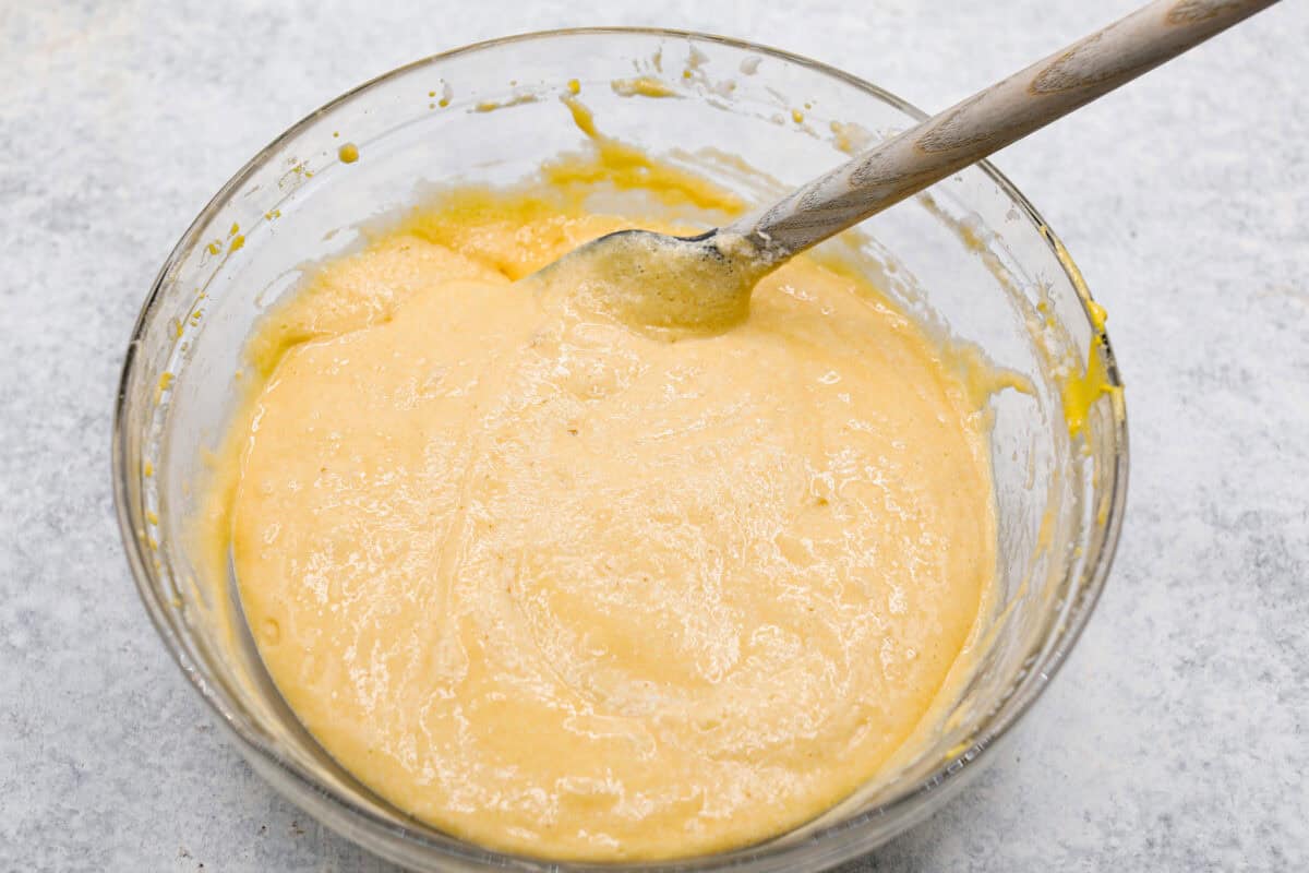 Overhead shot of whipped egg whites being folded into the flour and egg yolk mixture to make the cake batter. 