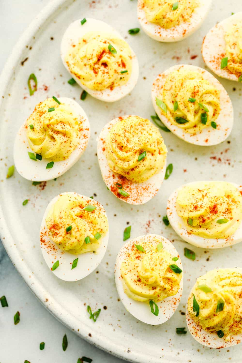Deviled eggs on a plate with paprika sprinkled on top.