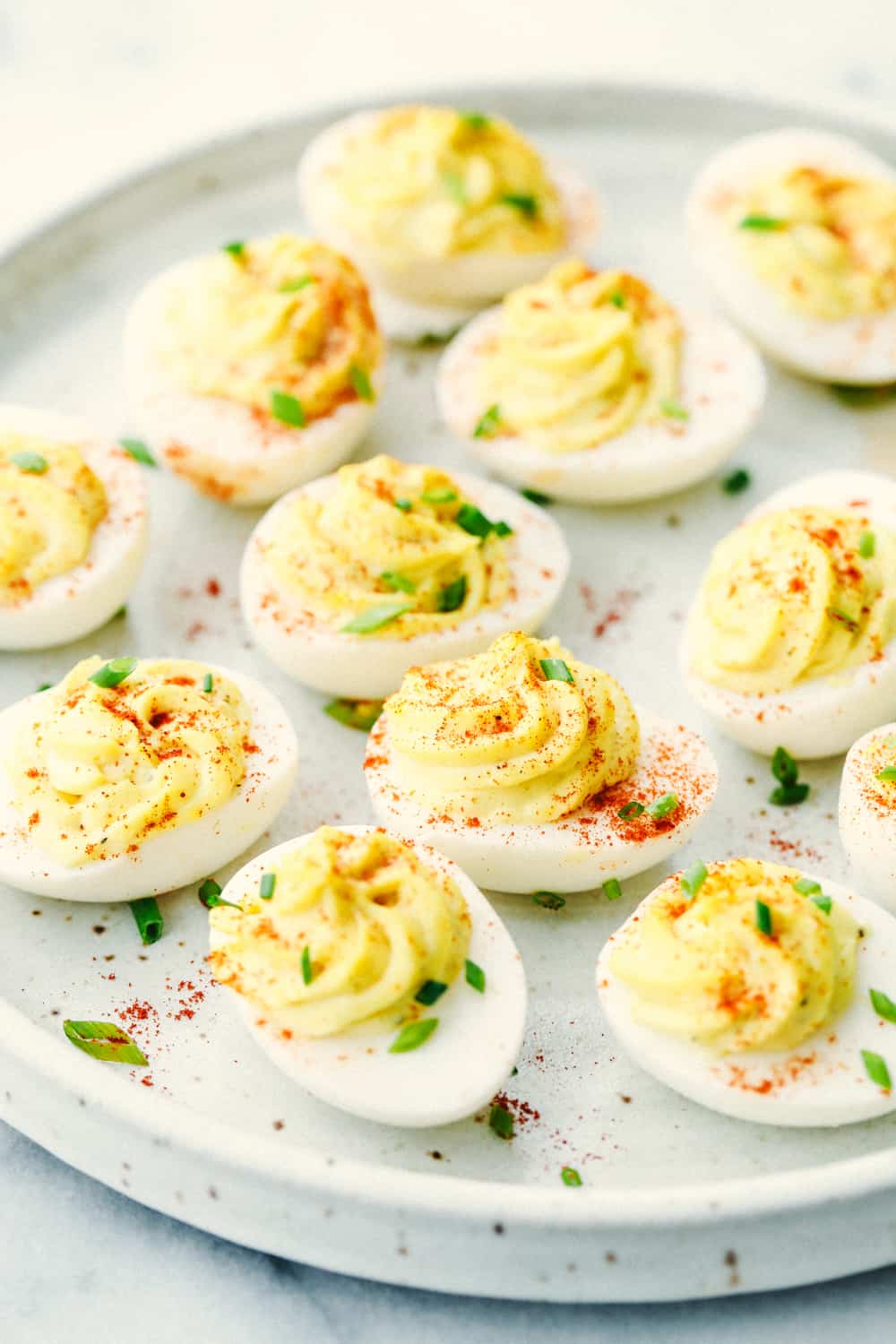 Deviled eggs on a plate with paprika sprinkled over top.